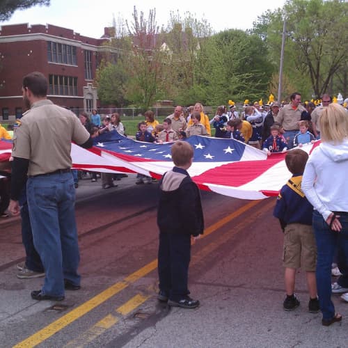 People stretching out an American Flag at a parade