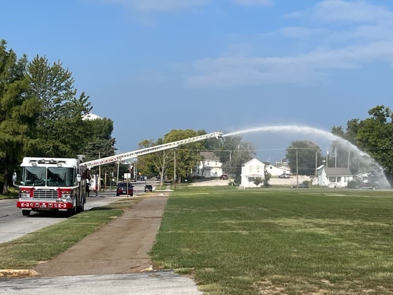 Firefighters in a field spraying water