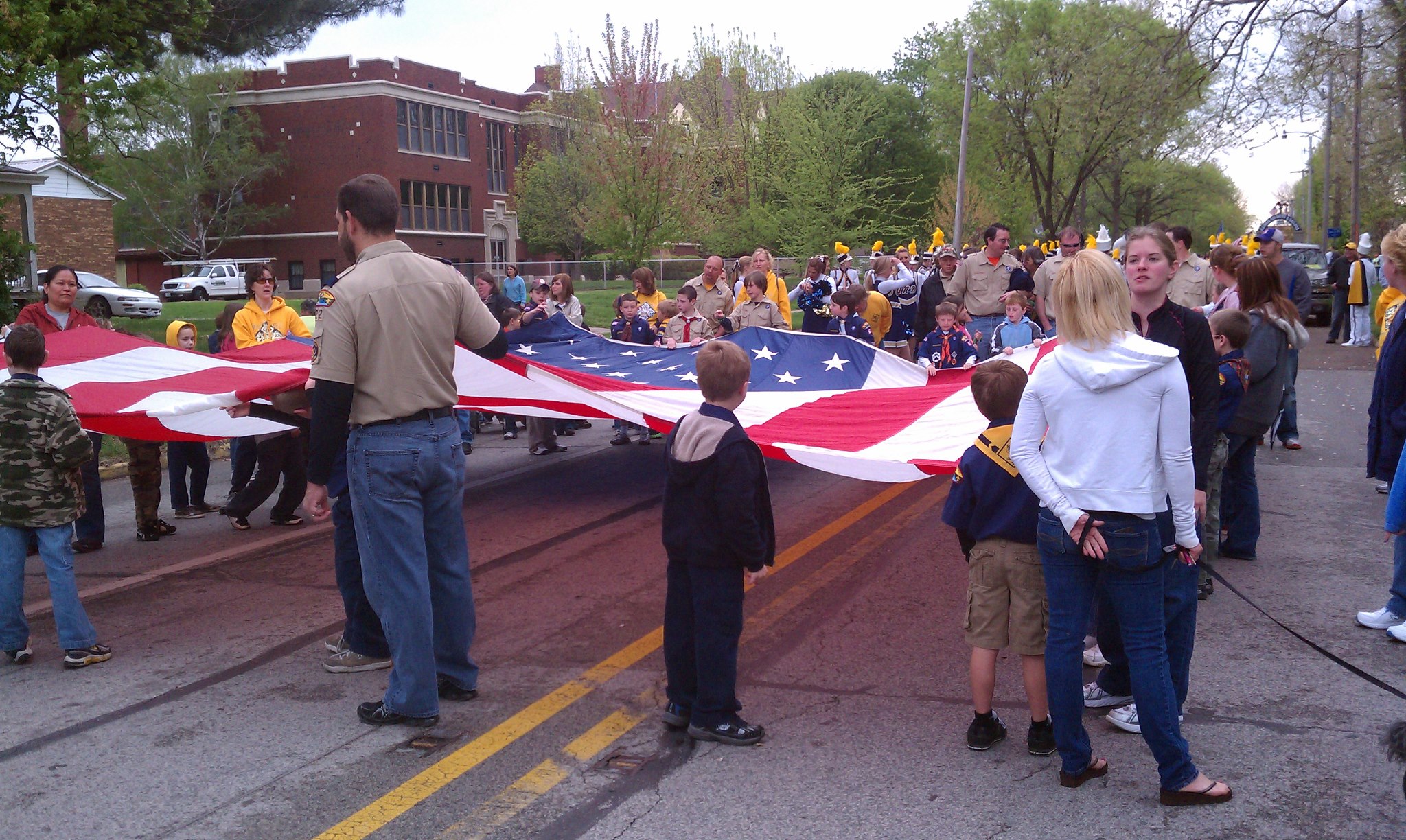 Large flag being held along a parade route