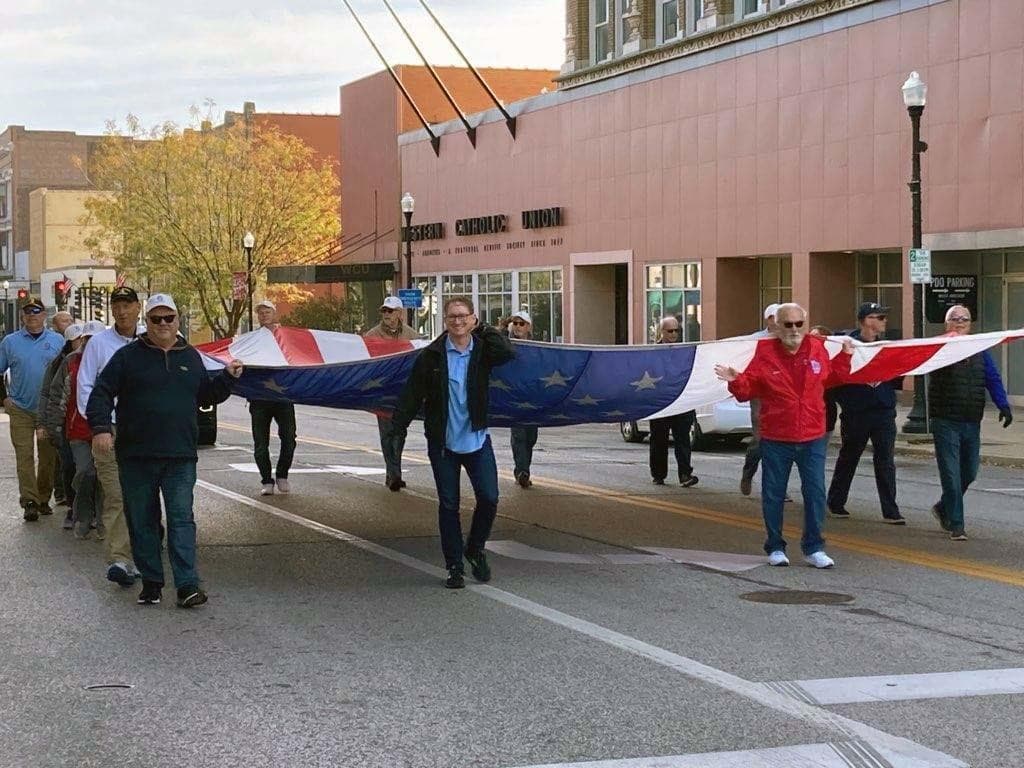 People holding large flag in a parade