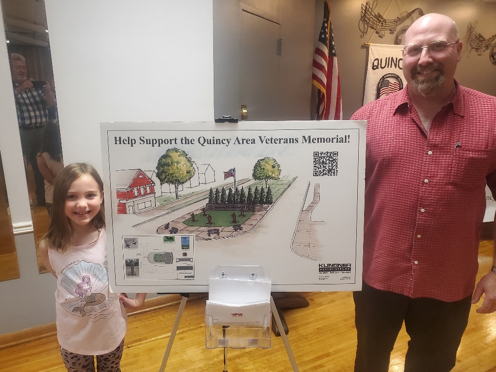 Jason Watkins and Margaret Watkins holding picture of development of Veteran's Memorial