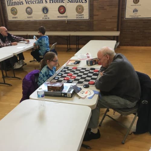 Veterans and kids playing checkers